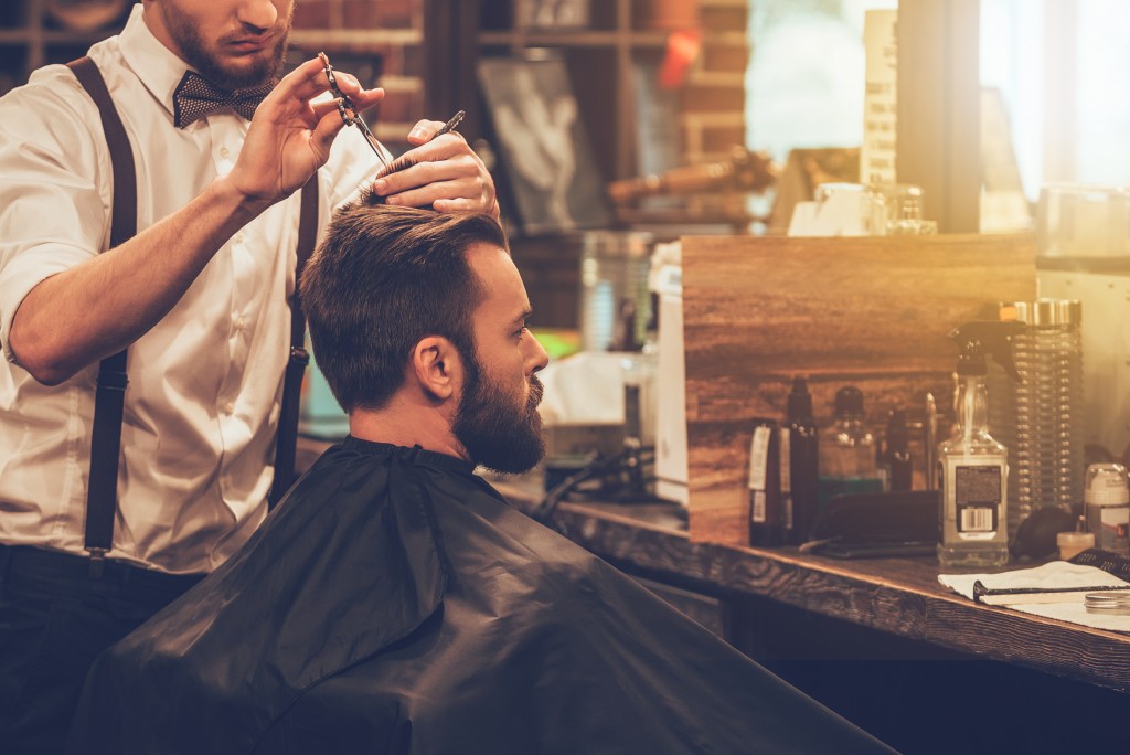 man getting a haircut in a barbershop