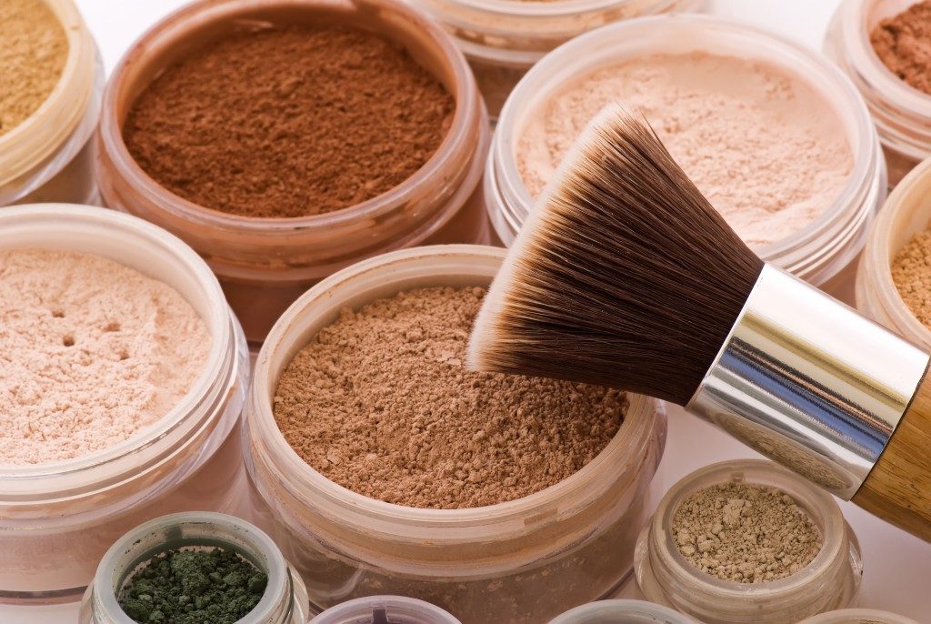 different colors of face powders and a brush
