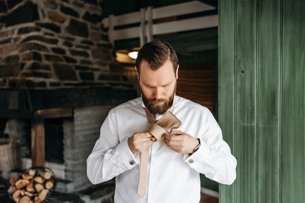Man with a Beard Fixing His Necktie