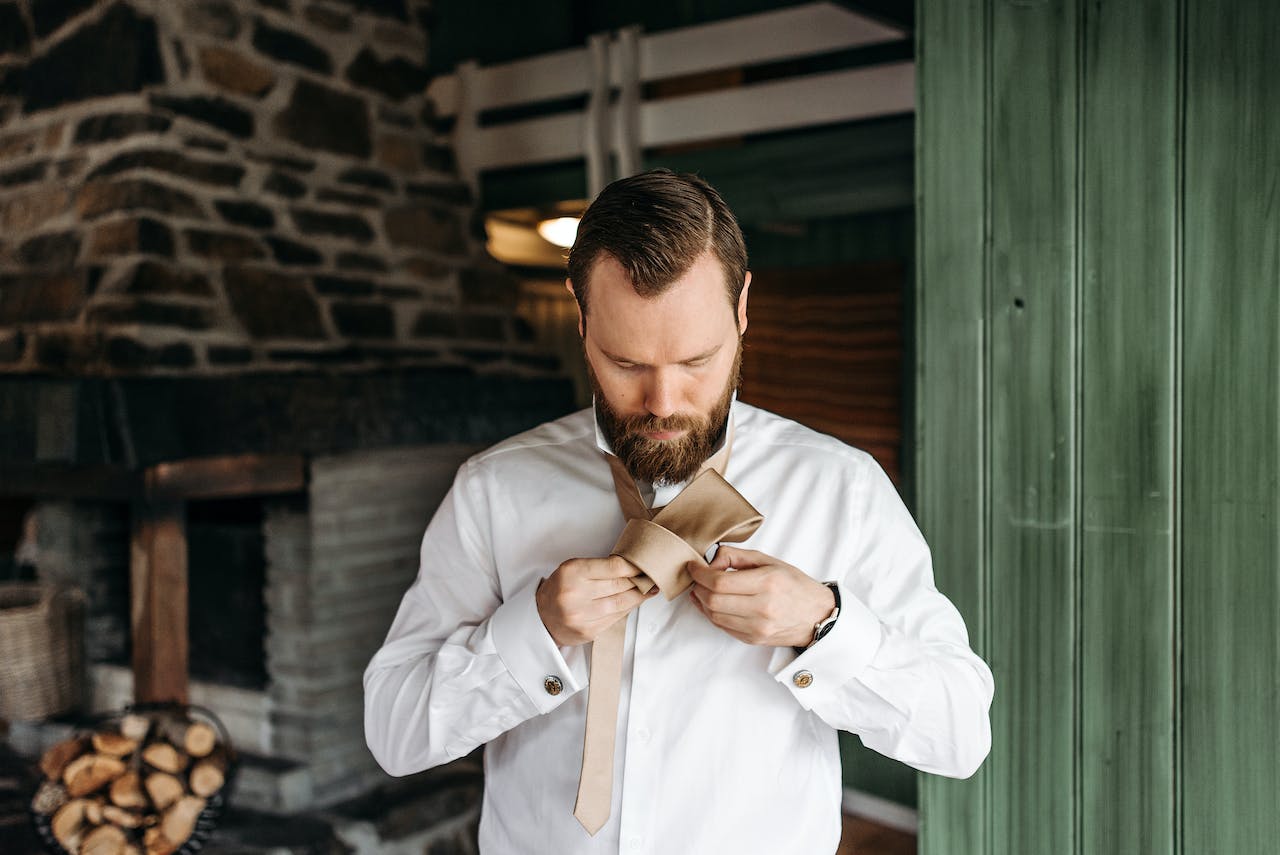 Man with a Beard Fixing His Necktie